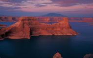 Deep blue water contained within orange-red cliff walls