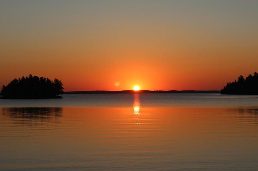 A brilliant sunset over the calm, cool waters of Rainy Lake