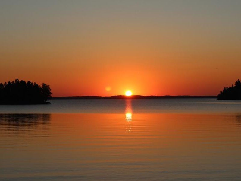 A brilliant sunset over the calm, cool waters of Rainy Lake Photos