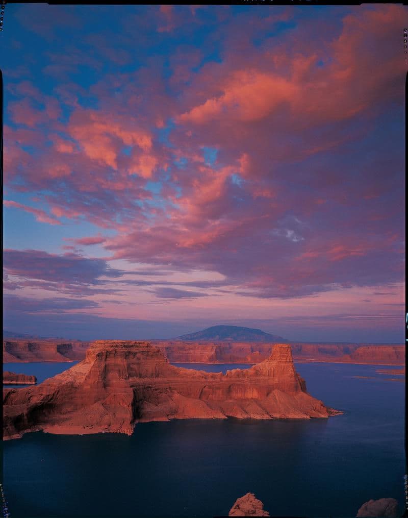Deep blue water contained within orange-red cliff walls
