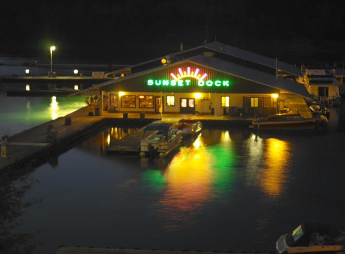 The Sunset Dock lit up after dark illuminates the lakes placid surface