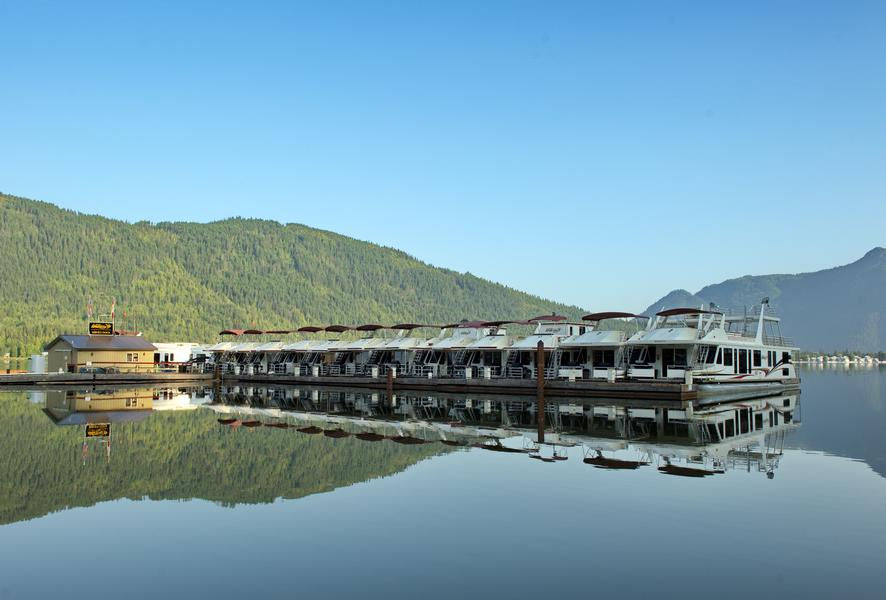 Luxurious houseboats lined up at the marina rest on pristine waters