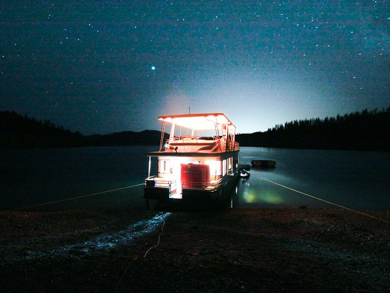 Shining lights from your houseboat illuminate against the star filled sky Photos