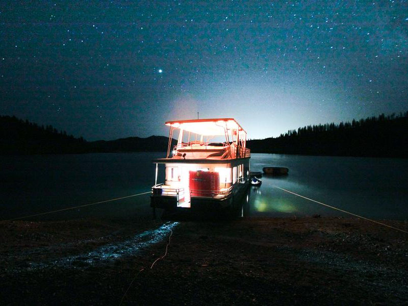 Shining lights from your houseboat illuminate against the star filled sky Shining lights from your houseboat illuminate against the star filled sky Photos